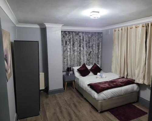 a small bedroom with a bed and a window at Sleek 2 bedroom flat-sleeps up to 5 guest in Hornchurch