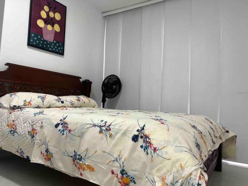1 dormitorio con 1 cama con edredón de flores en Espacio acogedor en Piedecuesta, Santander., en Piedecuesta