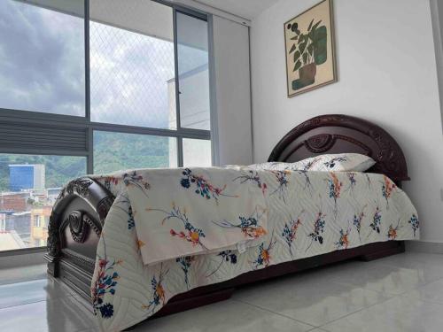 a bedroom with a bed with a floral comforter at Espacio acogedor en Piedecuesta, Santander. in Piedecuesta
