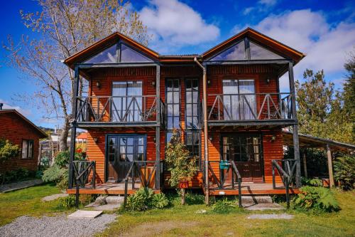 a log house with a porch and balcony at Cabañas Kompatzki in Ancud