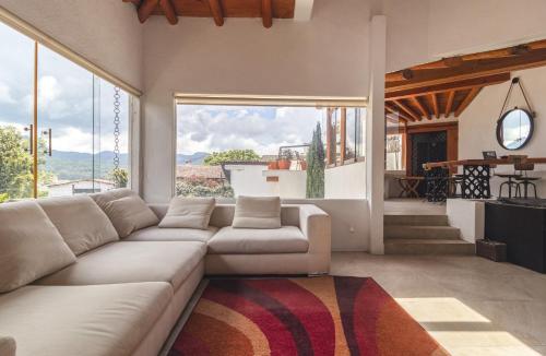 een woonkamer met een bank en een groot raam bij Lake view house with private pool in Valle de Bravo