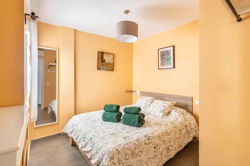 una camera da letto con un letto con due asciugamani verdi di Penthouse in Old Town, 100m from the beach a Fuengirola