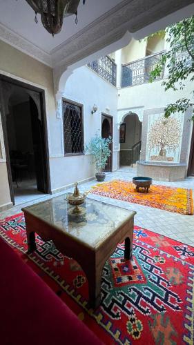 sala de estar con mesa y alfombra en RIAD GJULJA, en Marrakech