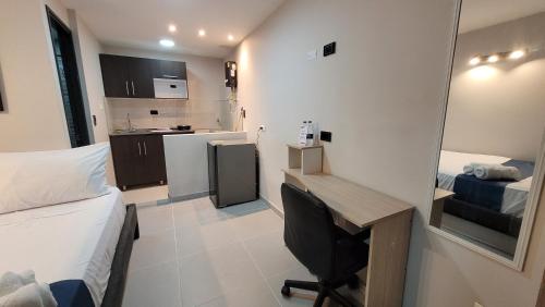 a small room with a desk and a bed and a kitchen at ANDALIVING CAMPO VALDÉS Estudio in Medellín