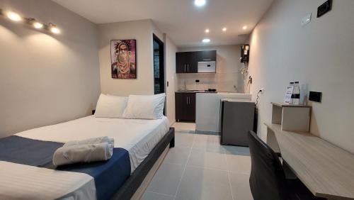 a small bedroom with a bed and a kitchen at ANDALIVING CAMPO VALDÉS Estudio in Medellín