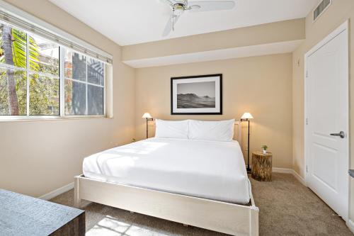 a bedroom with a large white bed and a window at Dharma Home Suites South Miami at Red Road Commons in Miami