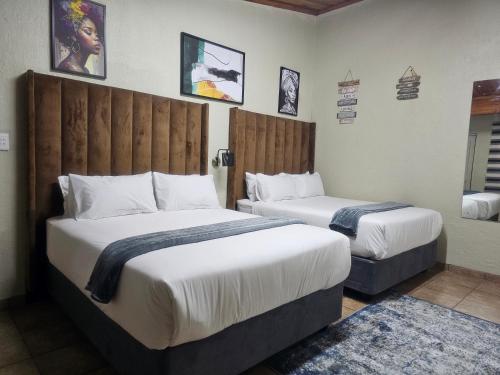 two beds in a hotel room with two beds at Yello Guest House Graskop in Graskop