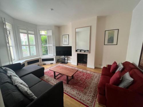 a living room with a couch and a table at Grand Tulse Hill Villa in London