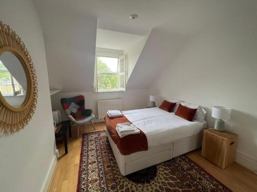 a bedroom with a bed with a mirror and a rug at Grand Tulse Hill Villa in London
