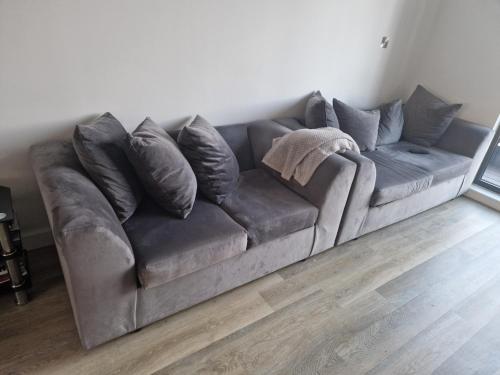 un sofá gris en la sala de estar en Stunning City View Apartment, en Londres
