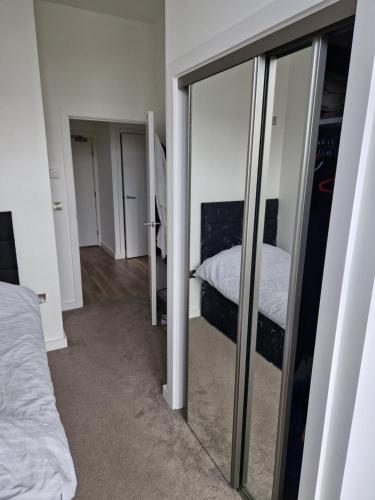 1 dormitorio con espejo y 1 cama. en Stunning City View Apartment, en Londres