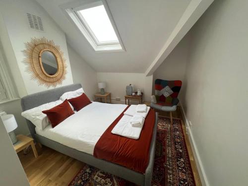 a bedroom with a bed and a skylight at Grand Tulse Hill Villa in London