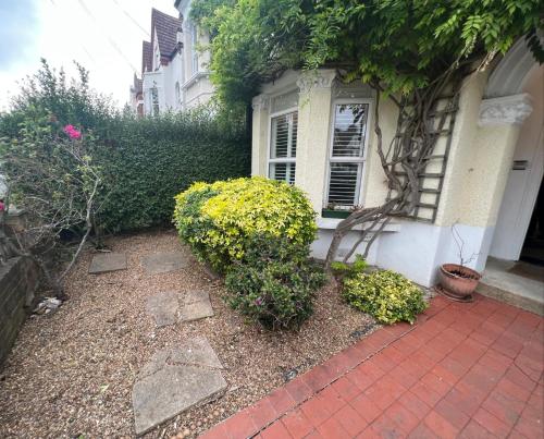 a house with a brick walkway in front of a house at Grand Tulse Hill Villa in London