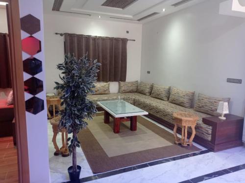 Appartement luxueux à louer à Taounate في تاونات: غرفة معيشة مع أريكة وطاولة