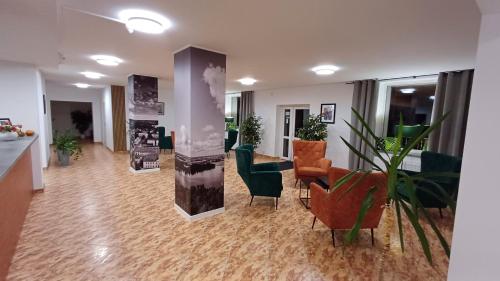 a living room with a lobby with furniture and plants at Hotel Piast in Myślibórz