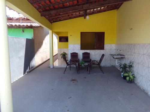 a patio with chairs and a table and a screen at Aconchego da Vó in Barreirinhas
