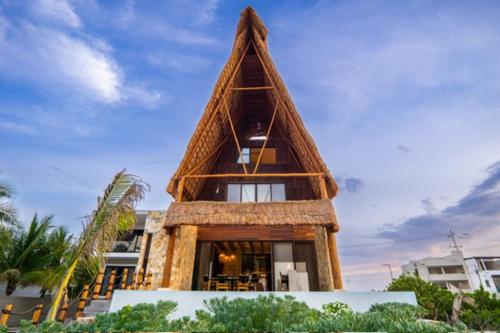a tall building with a triangular roof at Residencia Las Olas en San Benito lujo en todo su esplendor. in Progreso