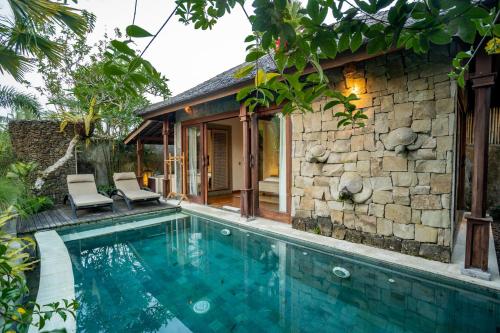 a villa with a swimming pool in front of a house at Nau Villa Ubud in Tegalalang