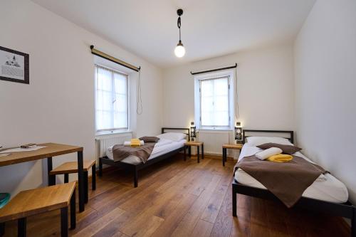 a room with two beds and a table and windows at Old Parish House in Bled