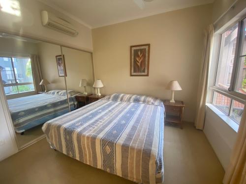 a bedroom with a bed and two windows at Lakes Resort 1 Bedroom Apartment in Edge Hill