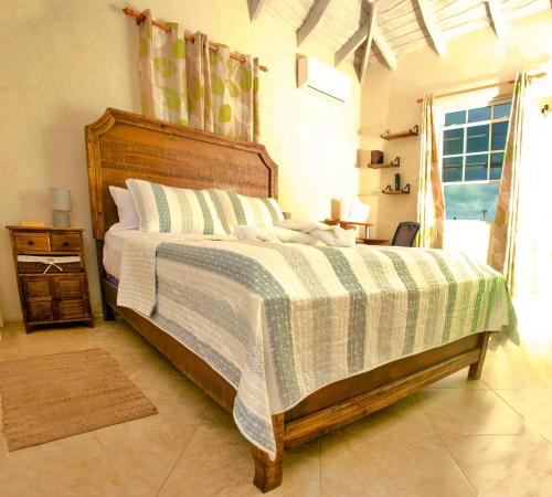 ein Schlafzimmer mit einem Bett mit einer grünen und weißen Decke in der Unterkunft Cozy Modern Upstairs 2 Bed A/C Apt Near 2 Everything in Saint Philip