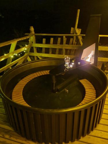 une baignoire jacuzzi sur la terrasse la nuit dans l'établissement Cabaña con hot tub privada y vista al río, à Linares