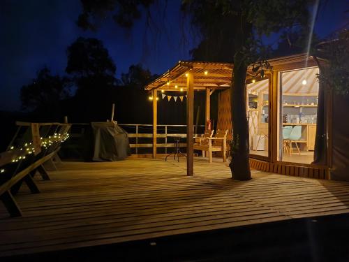 - une terrasse en bois avec un kiosque la nuit dans l'établissement Cabaña con hot tub privada y vista al río, à Linares