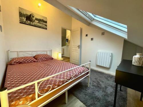 une chambre avec un lit, un bureau et une fenêtre dans l'établissement Chaleureux et convivial, à Saint-Quentin