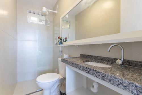a bathroom with a toilet and a sink at Beach Townhouses #C13 - Apartamento por Carpediem in Aquiraz