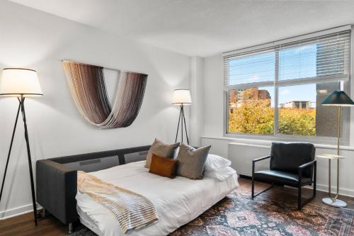 a bedroom with a bed and a chair and a window at CozyRetreat in Arlington