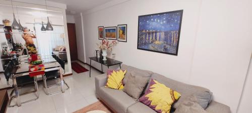 a living room with a couch and a kitchen at Quarto e banheiro privativos com garagem fechada em apartamento aconchegante em Jardim da Penha in Vitória