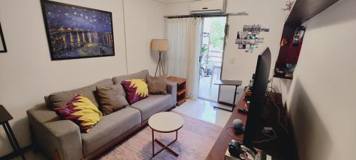 a living room with a couch and a table at Quarto e banheiro privativos com garagem fechada em apartamento aconchegante em Jardim da Penha in Vitória