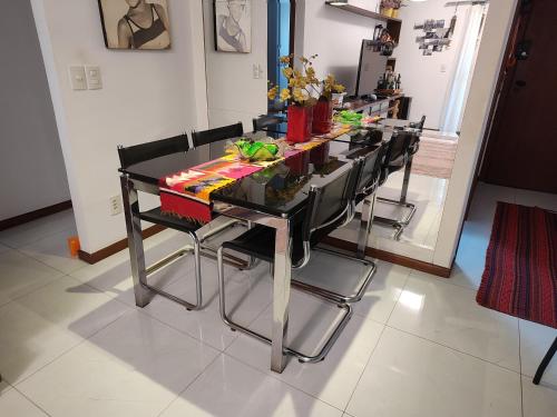 a dining room table with black chairs in a room at Quarto e banheiro privativos com garagem fechada em apartamento aconchegante em Jardim da Penha in Vitória