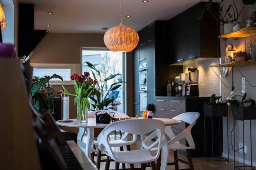 una cucina con tavolo e sedie bianche di Hygge houses I Apartment with panorama view a Lillestrøm