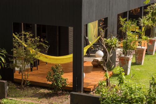 a hammock on the deck of a house at Pousada Vila do Mel in Pontal do Paraná