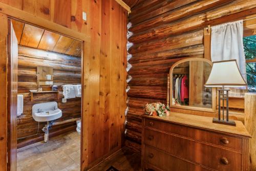 a log cabin bathroom with a sink and a mirror at Shelter Cove Resort & Marina in Odell Lake