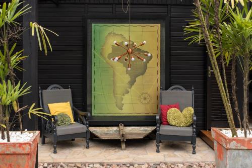 two chairs and a door with a heart painted on it at Pousada Vila do Mel in Pontal do Paraná