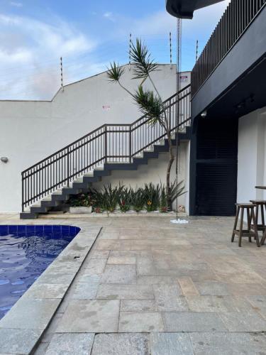 a patio with a staircase next to a house at Acomodações do Tio Will - 2 in Guarujá
