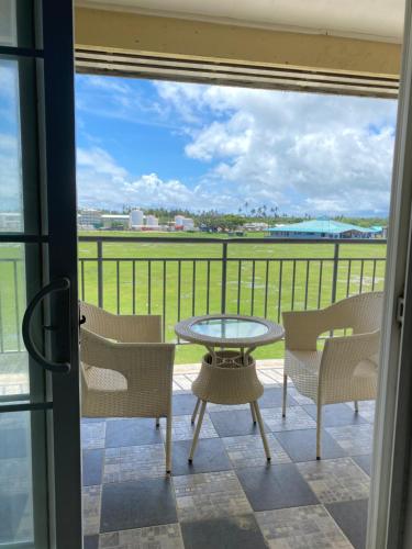 um pátio com uma mesa e cadeiras numa varanda em Dupincia Lodge em Nuku‘alofa