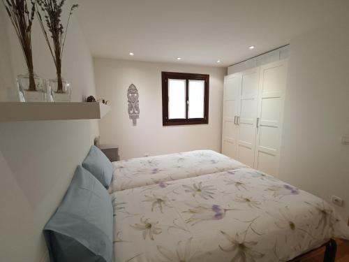 ein Schlafzimmer mit einem Bett mit Blumenmuster darauf in der Unterkunft Casa Rural Runa in Miranda de Arga
