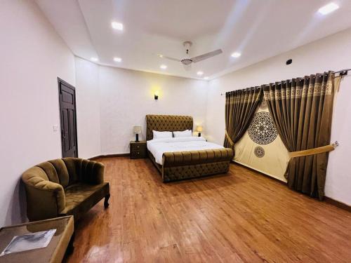 a bedroom with a bed and a couch and a chair at Apex Inn Guest House in Islamabad