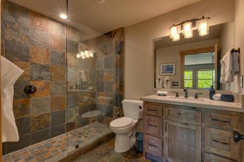 a bathroom with a toilet and a shower and a sink at Spruce Haven by Tahoe Getaways at Tahoe Donner - Luxury Pet Friendly Cabin w Private Hot Tub in Truckee