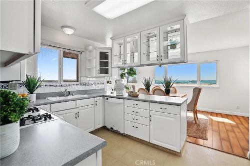 a kitchen with white cabinets and a view of the ocean at Beachfront 3 Bedroom 3 Bath In Seal Beal, Ca in Seal Beach