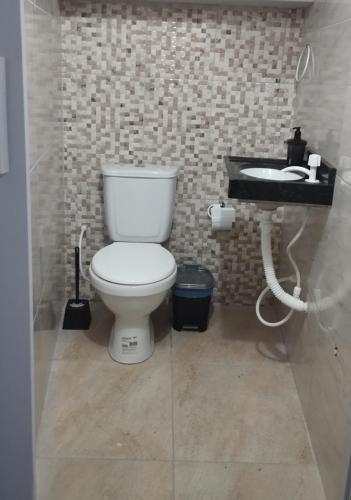a bathroom with a white toilet and a sink at Sua casa completa em Viçosa do Ceará in Viçosa do Ceará