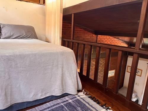 a bedroom with a bed and a brick wall at Buganville Loft in Abraão