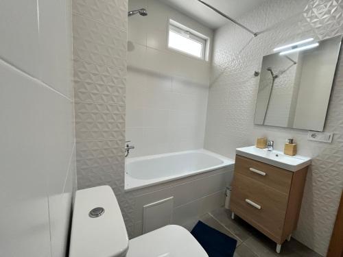 a bathroom with a tub and a toilet and a sink at Las Piteras in Playa de las Americas