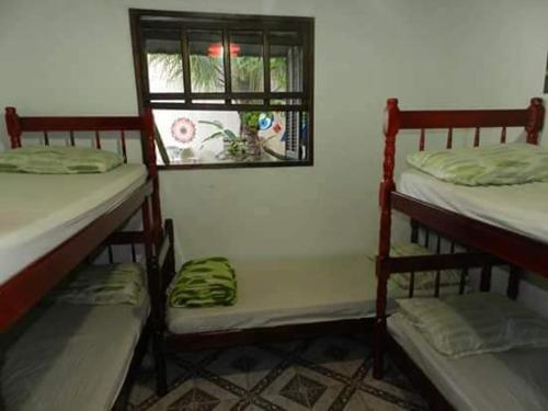two bunk beds in a room with a window at Hostel Resende in Resende