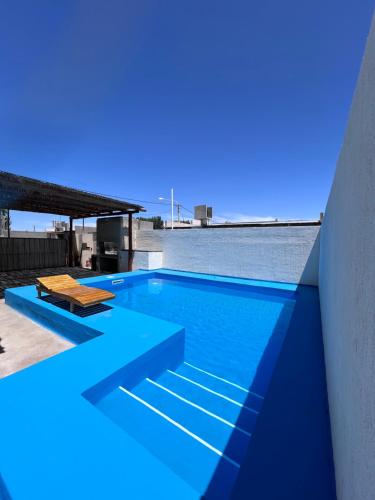 a blue swimming pool with a view of the ocean at Casa con pileta privada in General Alvear