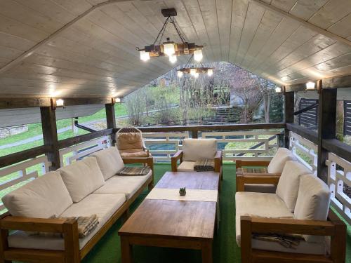a living room with couches and tables in a train car at Шале Маєток Смерековий in Slavske
