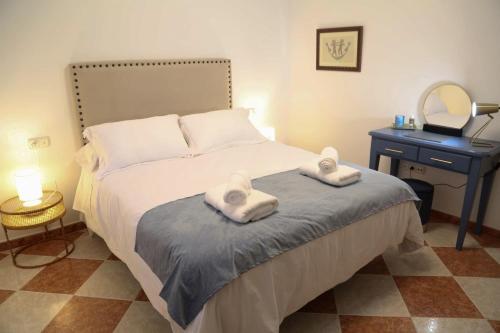 a bedroom with a bed with two towels on it at Casa Centro Fuengirola in Fuengirola